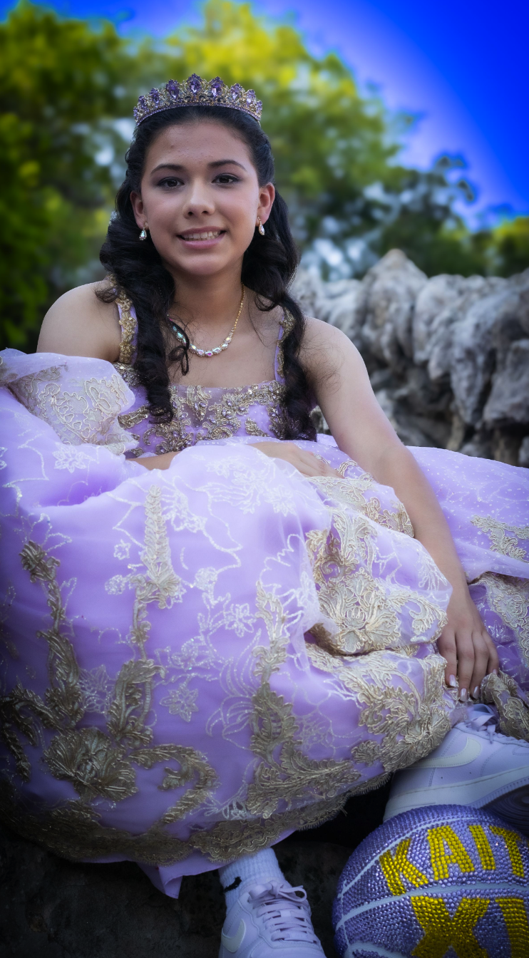 Quinceañera in lilac gown with tiara holding her basketball