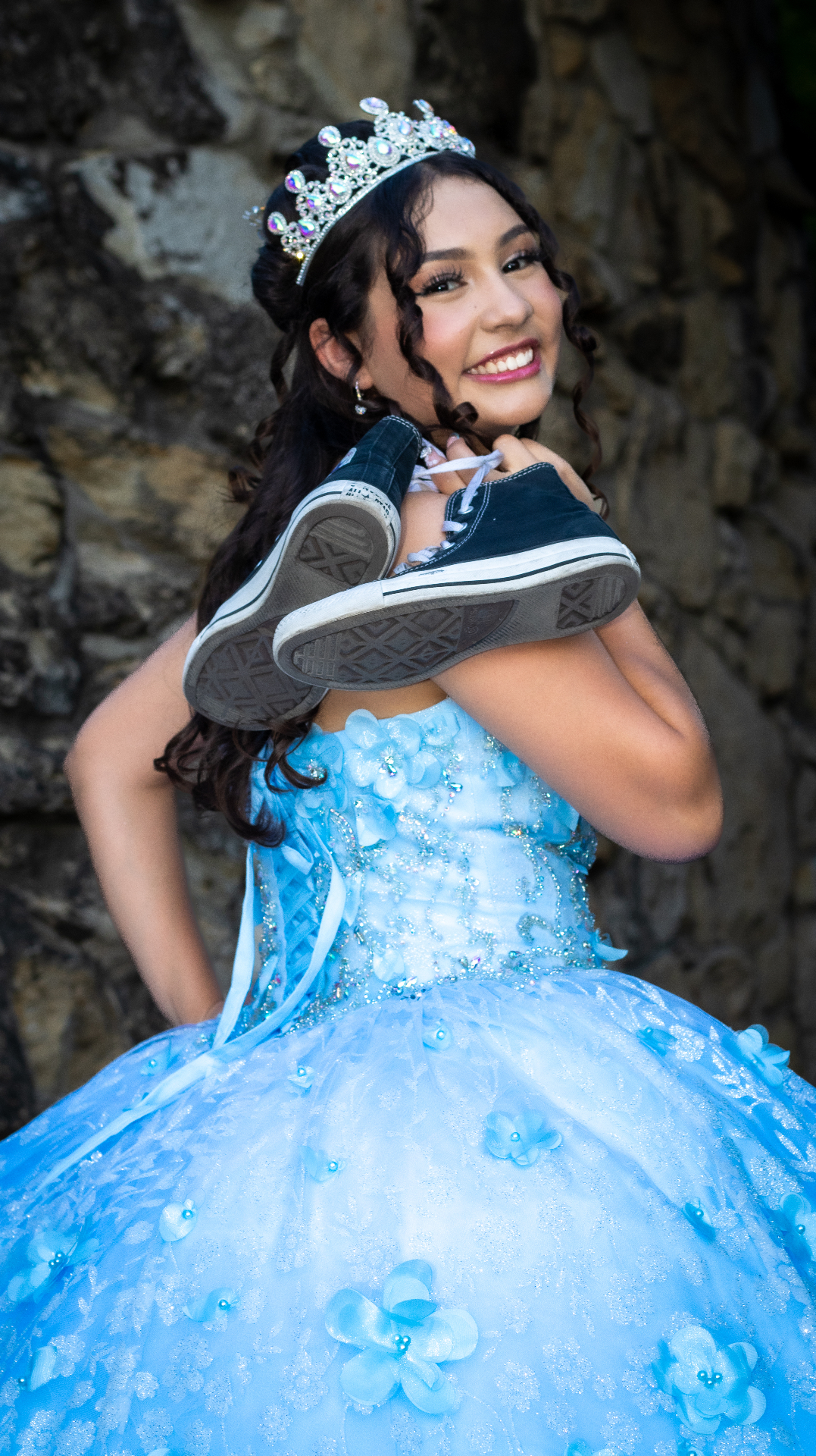 Quinceañera holding sneakers with her tiara