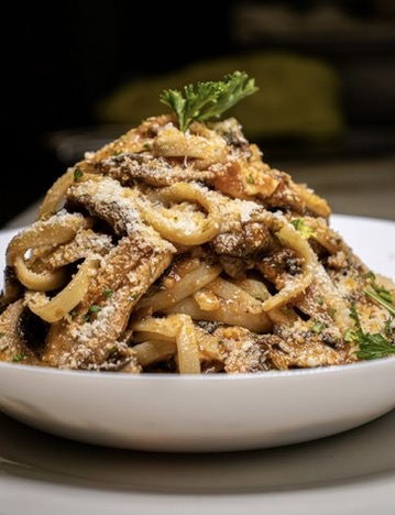 Creamy pasta plated high with parmesan and parsley