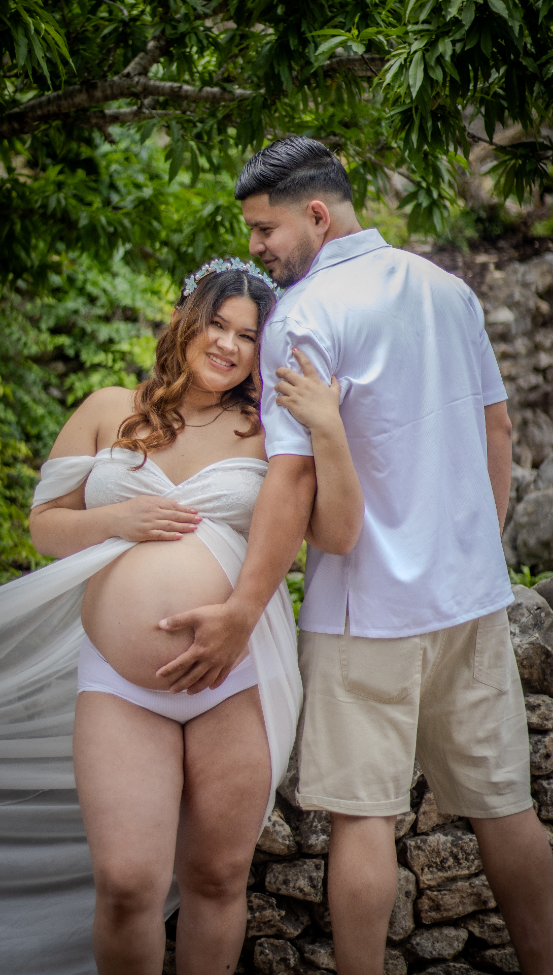 Expecting mother in white with partner outdoors