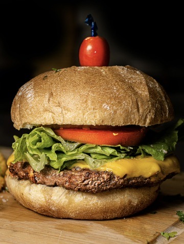Handcrafted cheeseburger on a wooden board