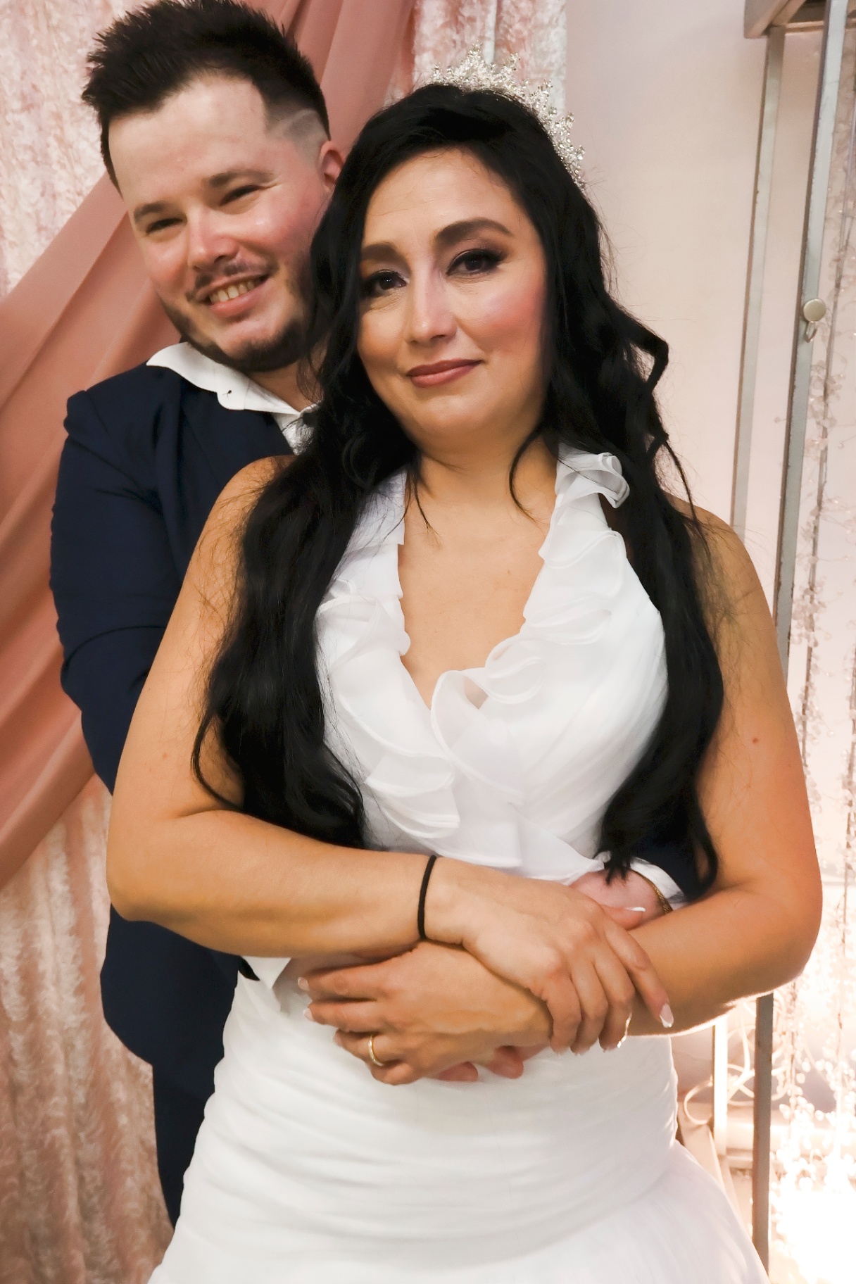 Groom embracing the bride from behind