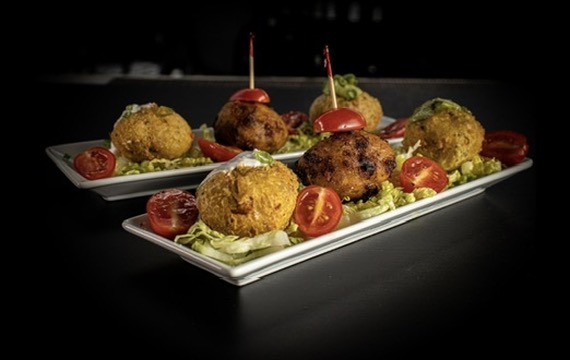 Croquettes with cherry tomatoes on white plates
