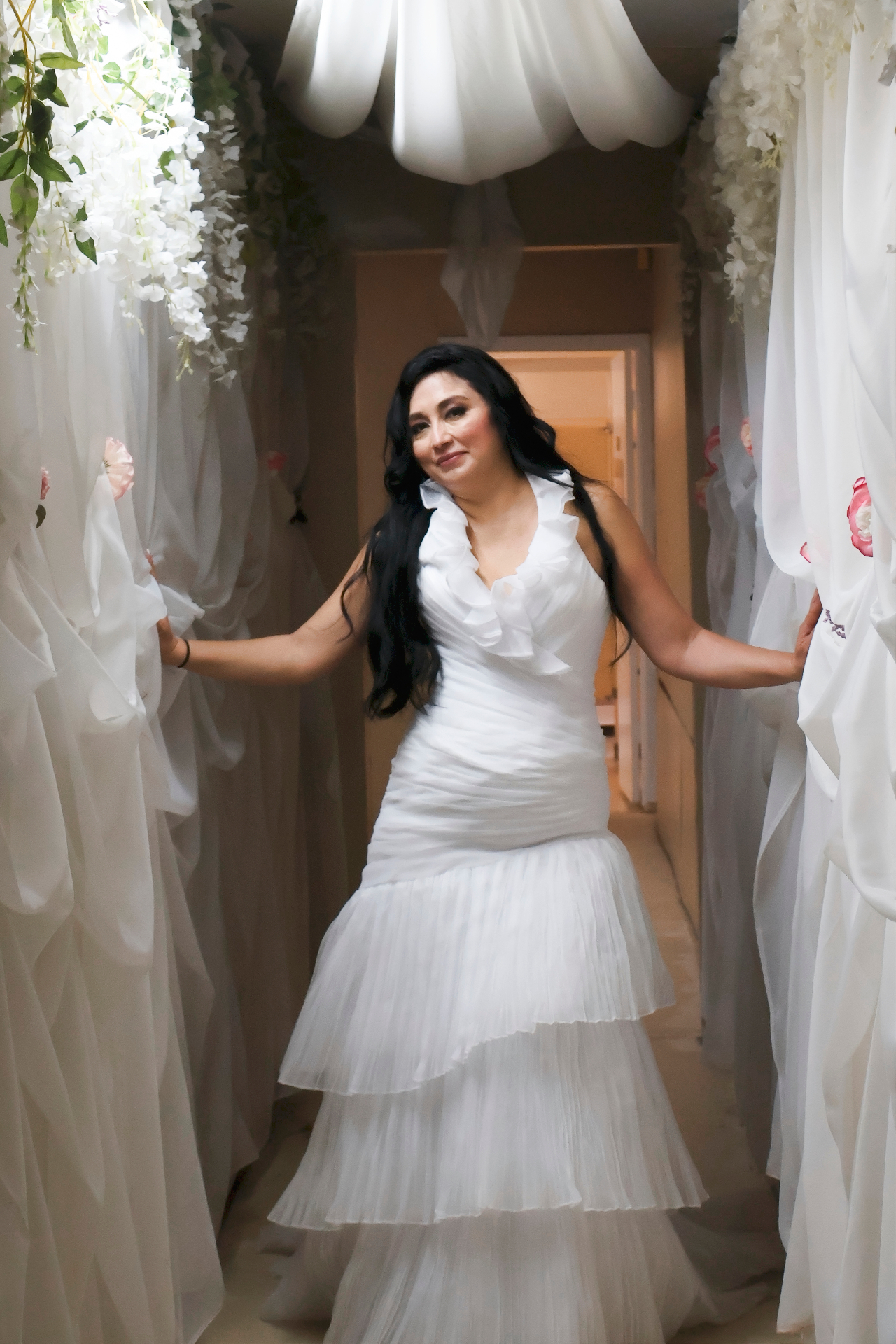 Bride framed by white floral drapery
